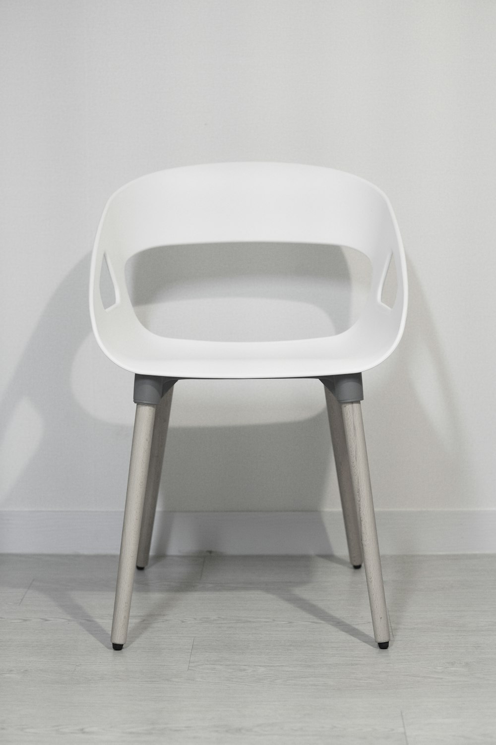 white plastic chair on white floor tiles