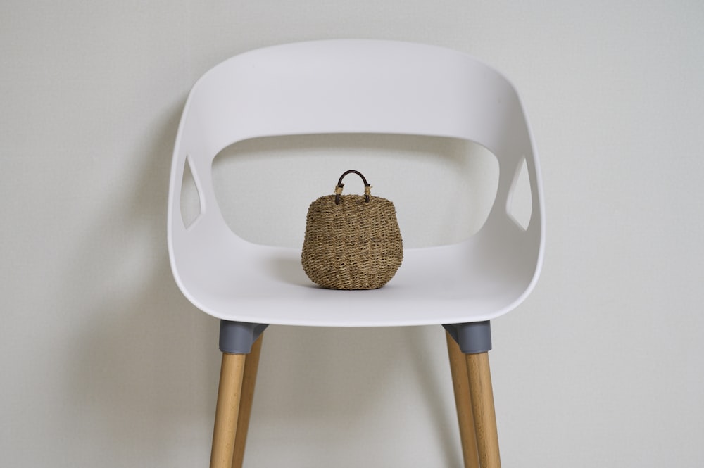 brown wicker basket on white plastic chair