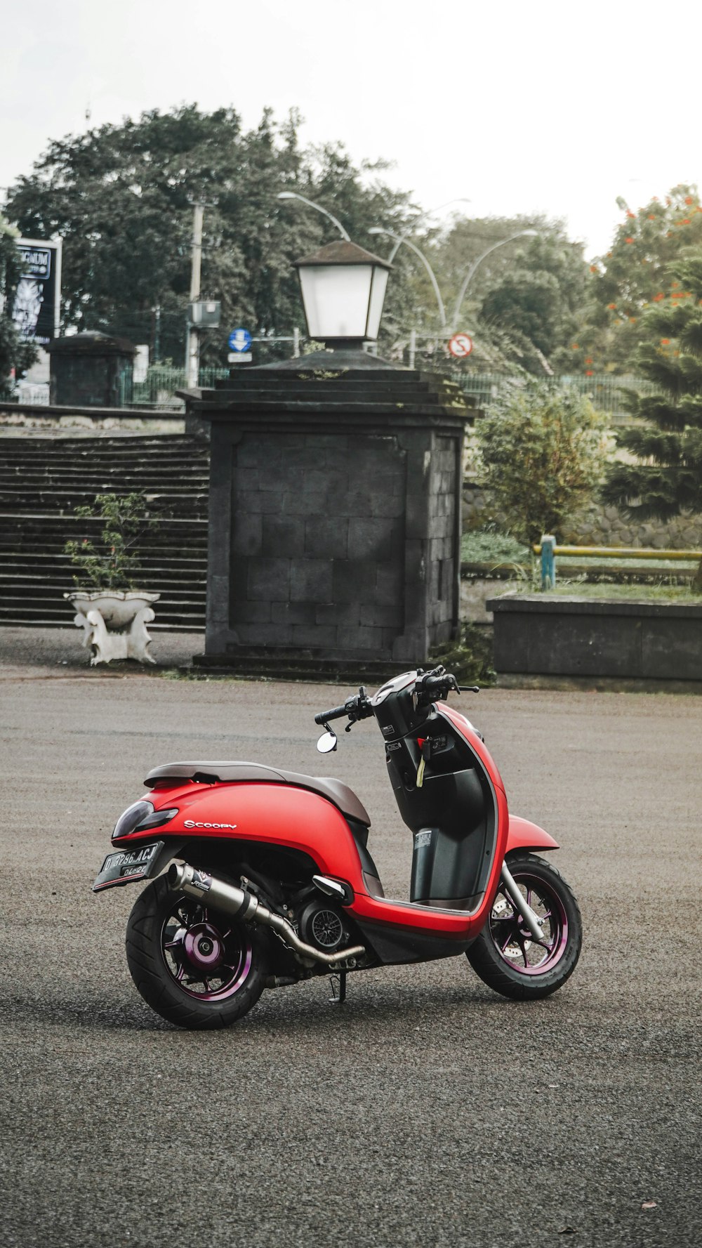 red and black motorcycle parked beside black wooden door