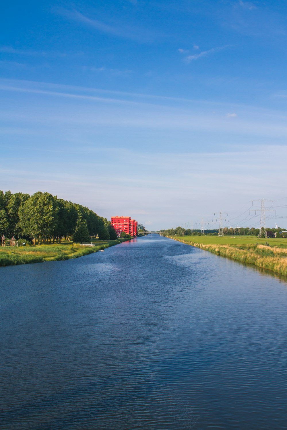 Grünes Grasfeld in der Nähe von Gewässern unter blauem Himmel tagsüber