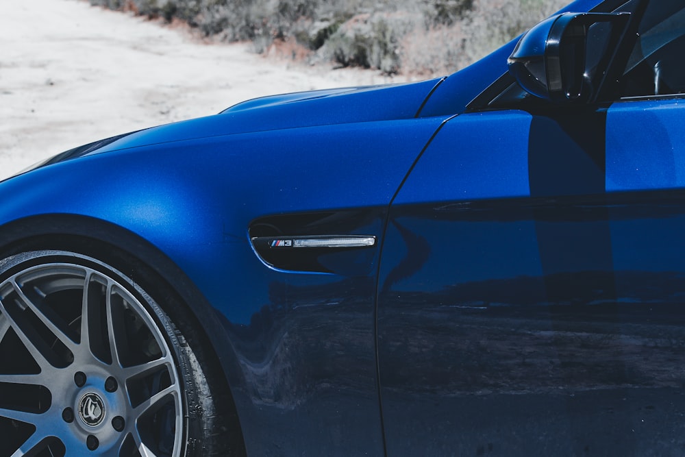 Blaues Auto tagsüber auf grauem Sand
