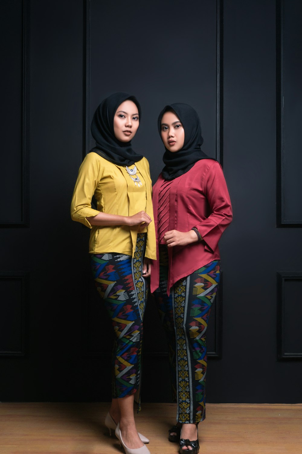 woman in yellow and red long sleeve shirt beside woman in red hijab