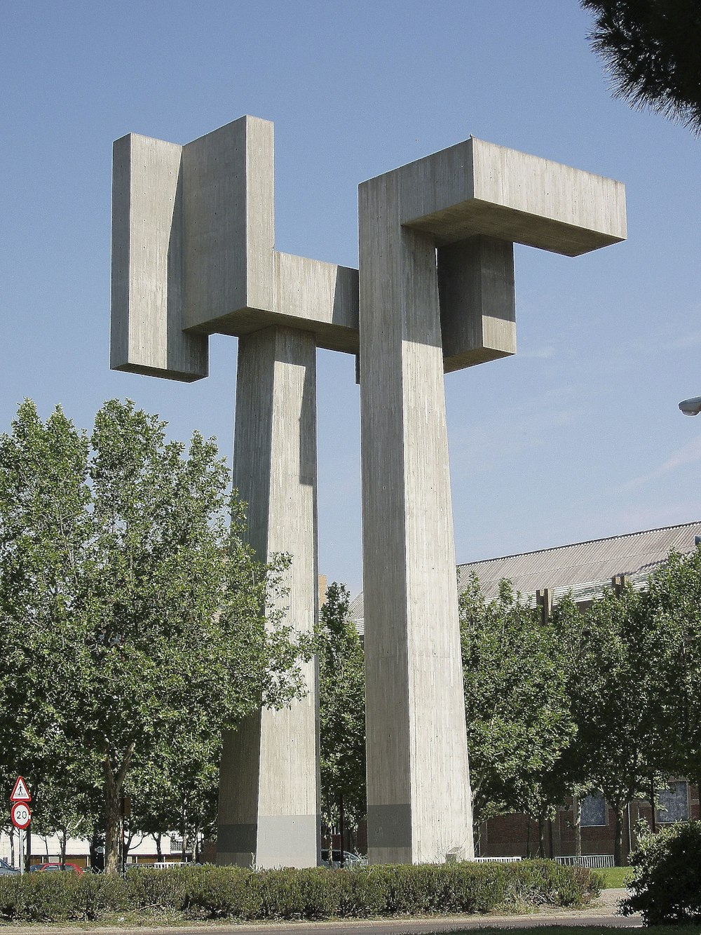 gray concrete cross statue near green trees during daytime