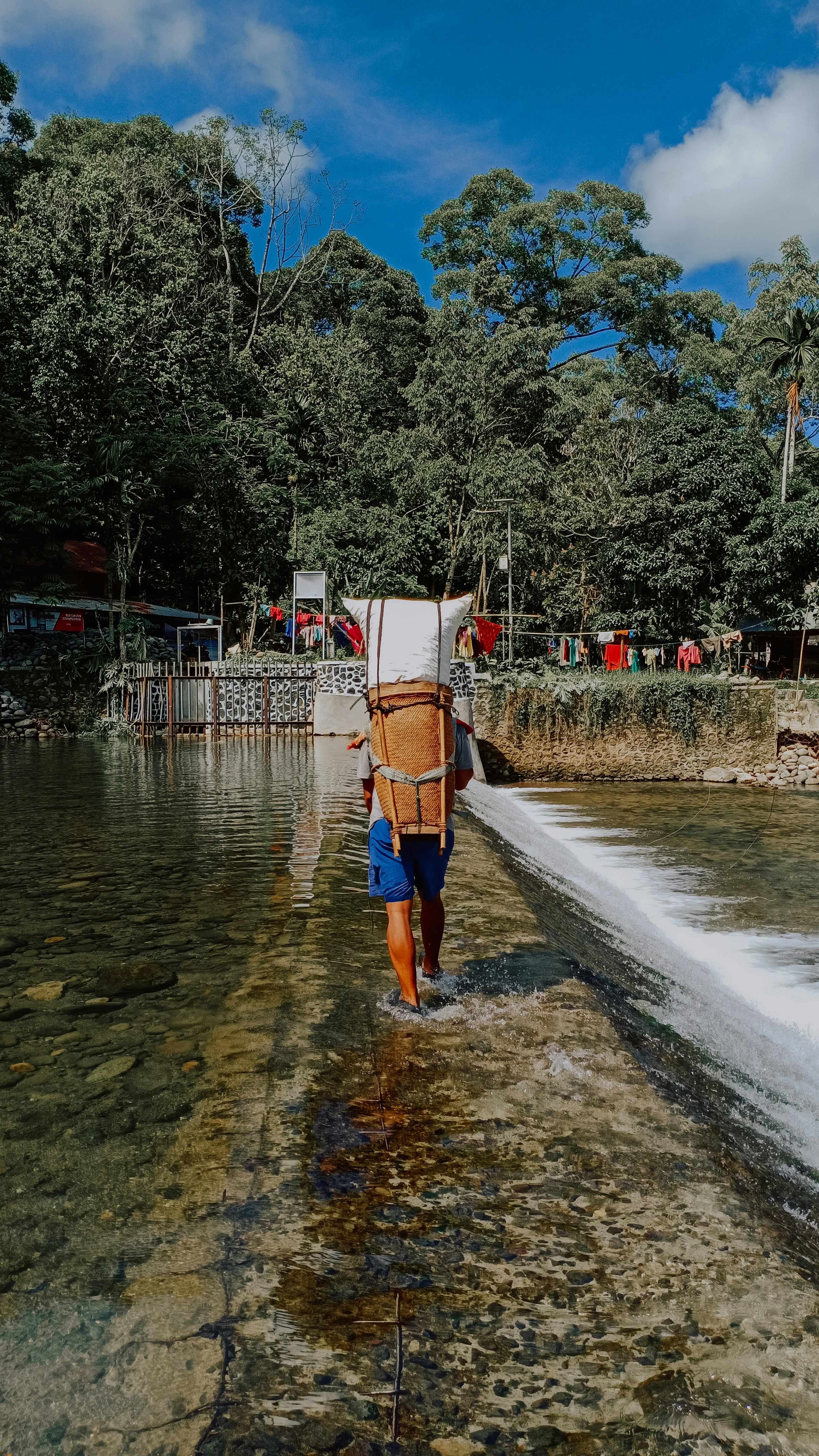 Man in orange shorts standing on water during daytime photo Free