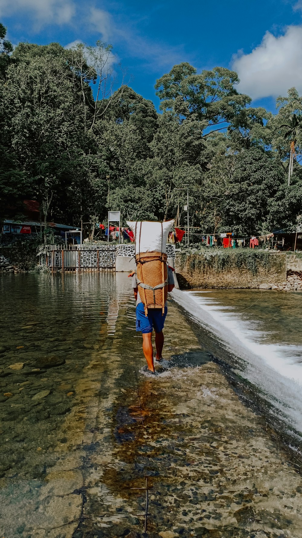 man in orange shorts standing on water during daytime