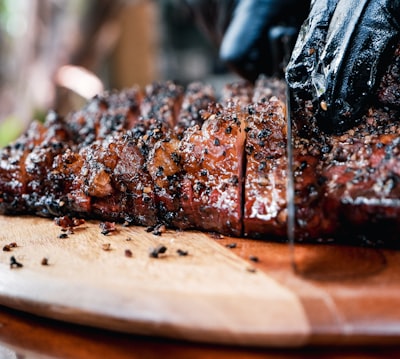 grilled meat on brown wooden chopping board roast teams background