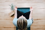 woman in black shirt and gray pants sitting on brown wooden bench