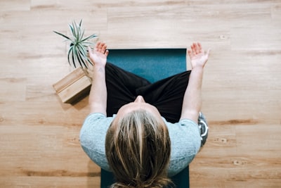 woman in black shirt and gray pants sitting on brown wooden bench mindfulness zoom background