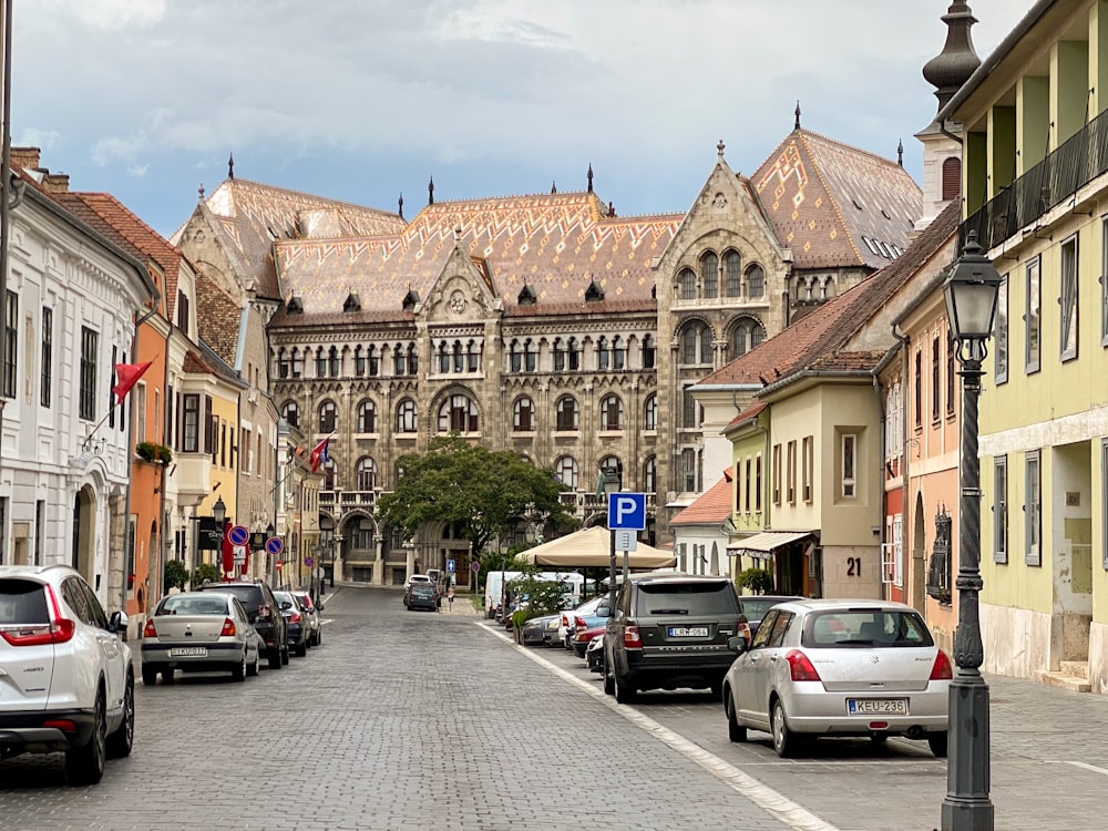 a street lined with parked cars next to tall buildings