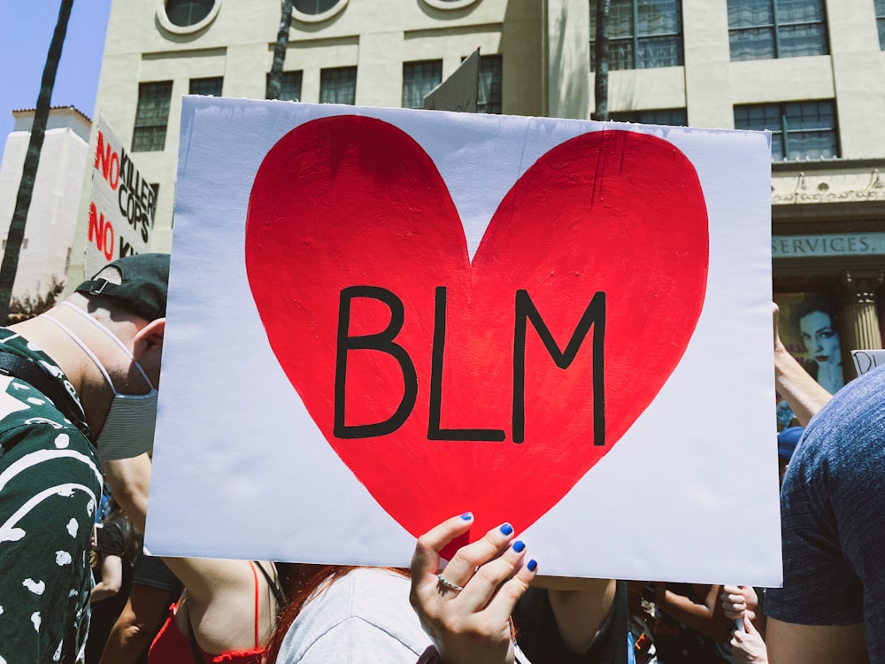 woman holding red love heart banner