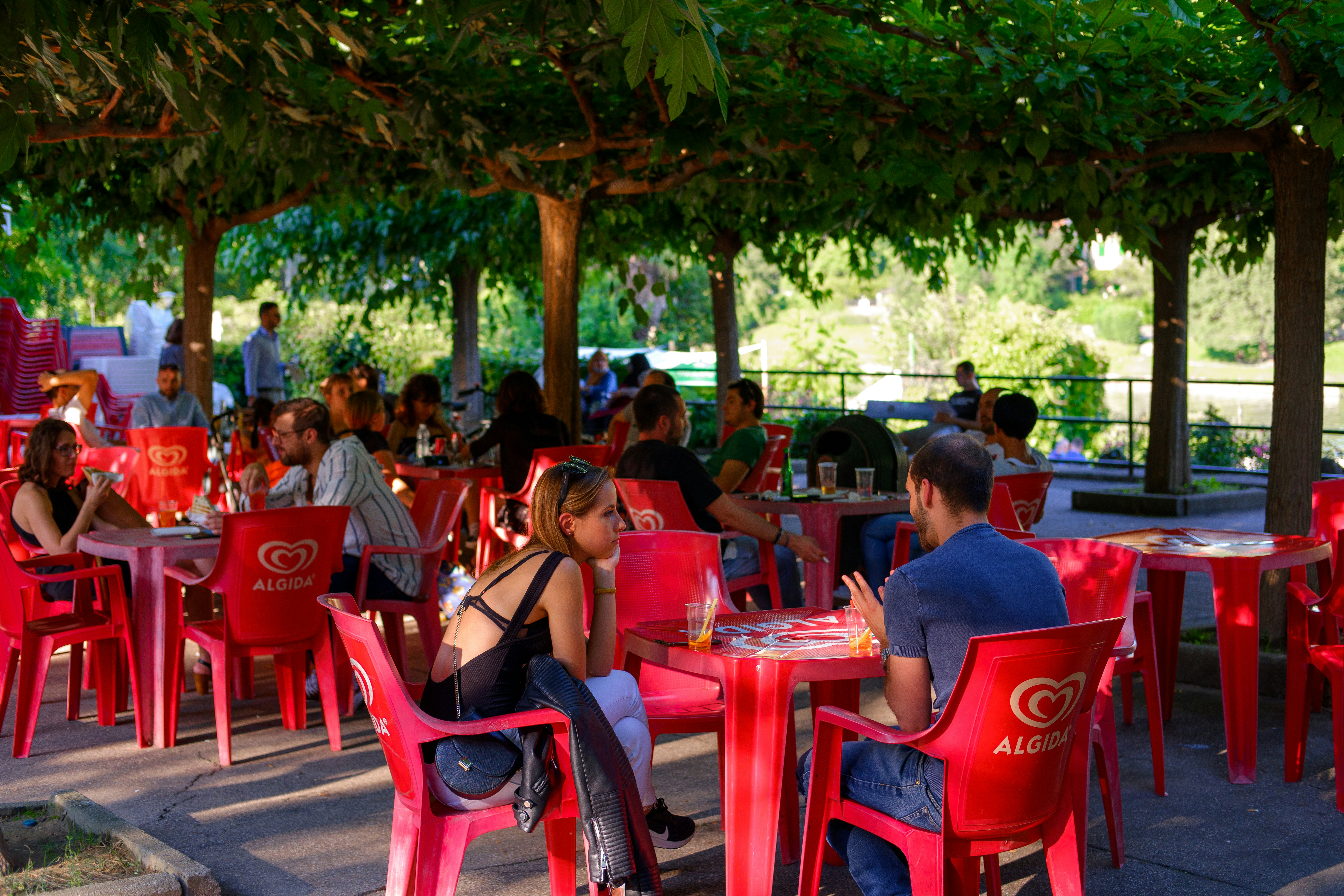 people sitting on red plastic chairs during daytime, 