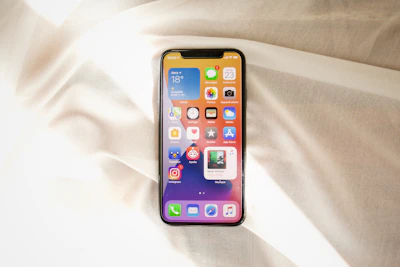 Smartphone resting on a colorful fabric background.