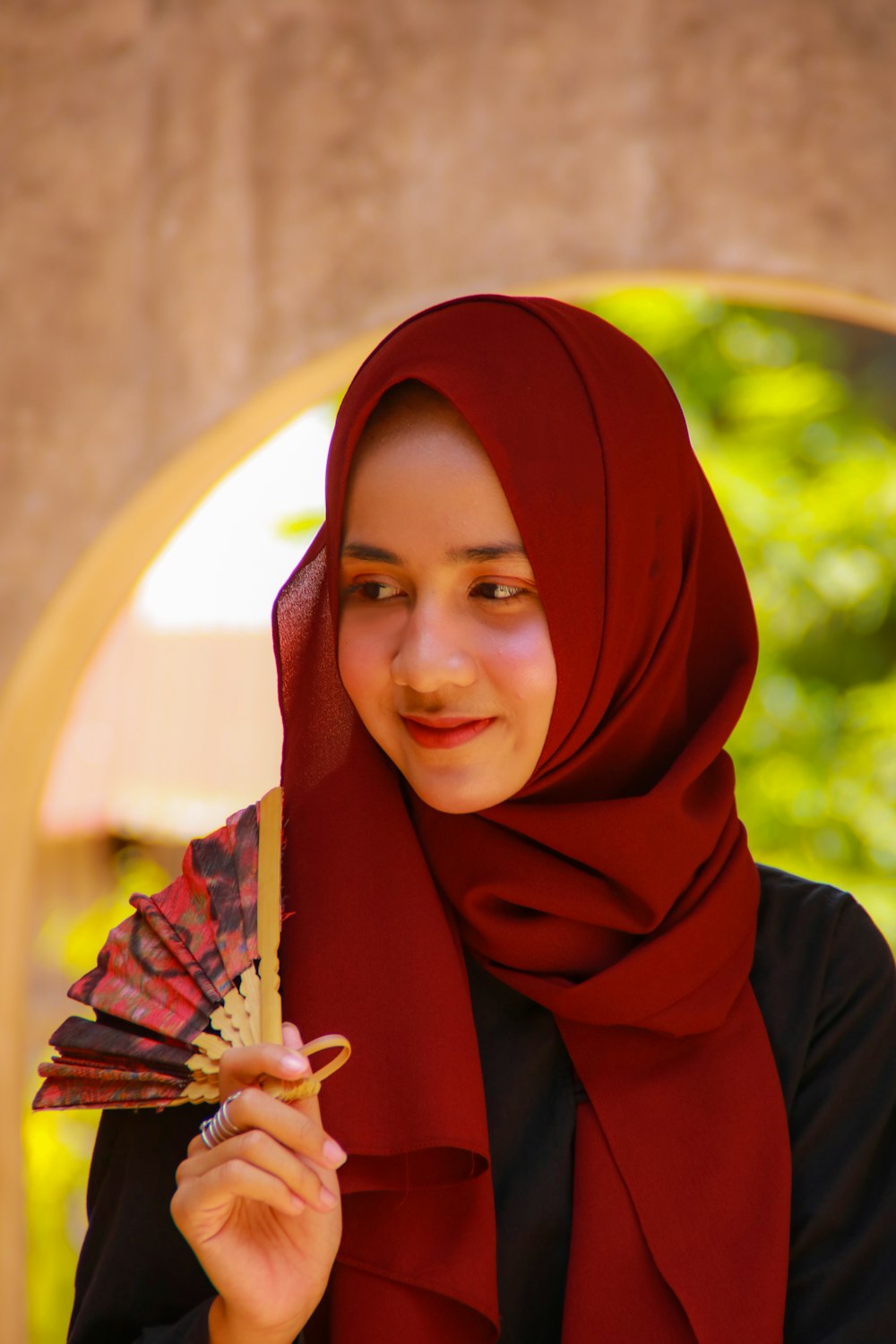 woman in red hijab holding white and brown stick