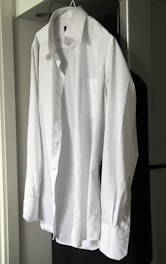 Close-up of a crisp white dress shirt with subtle texture on a green backdrop.