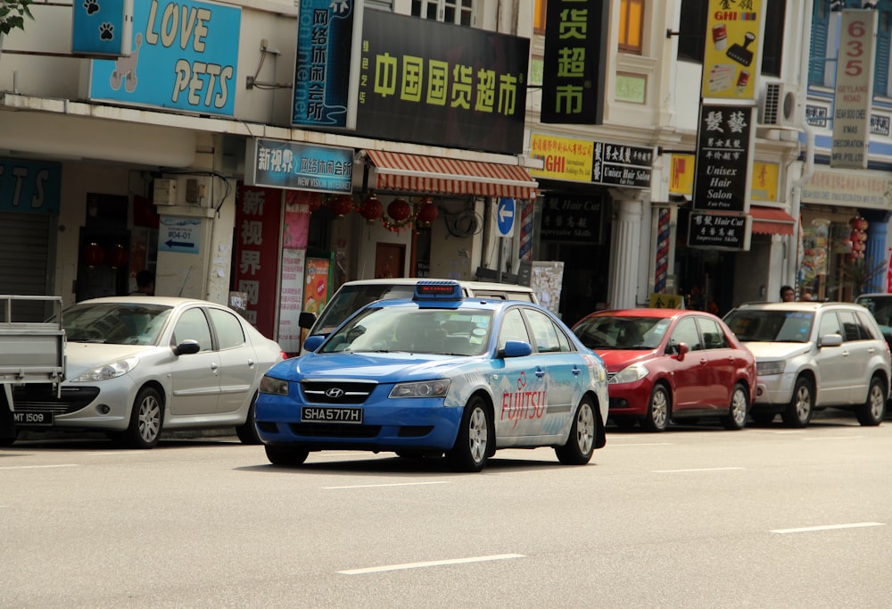 blue and white sedan on road near store during daytime