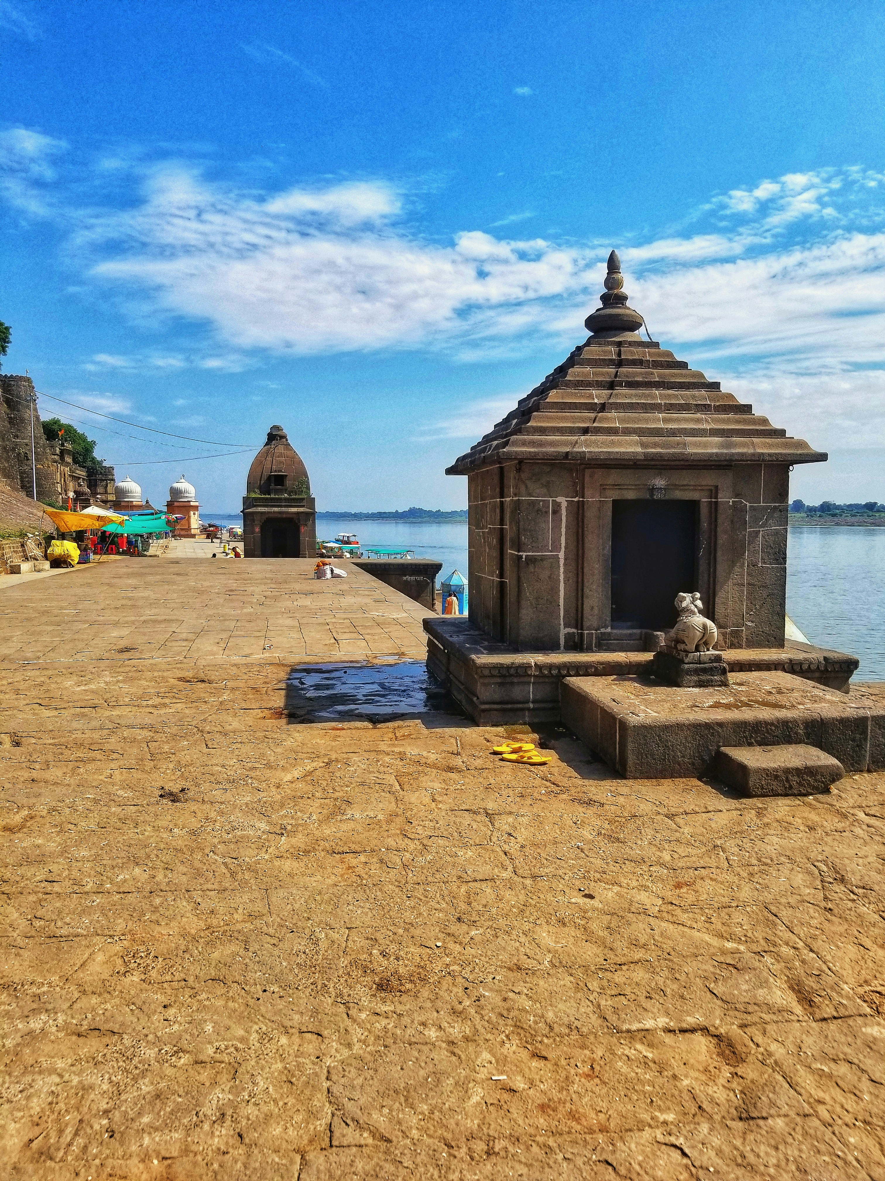 brown wooden house near body of water during daytime