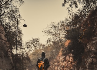 man in black jacket and black pants walking on road during daytime