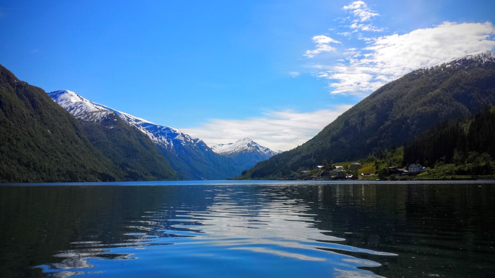 lake near mountain under blue sky during daytime