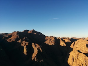 A panoramic view of a rugged mountain range under a clear blue sky, symbolizing strength and endurance.