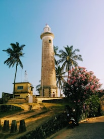 white and brown lighthouse near green trees during daytime