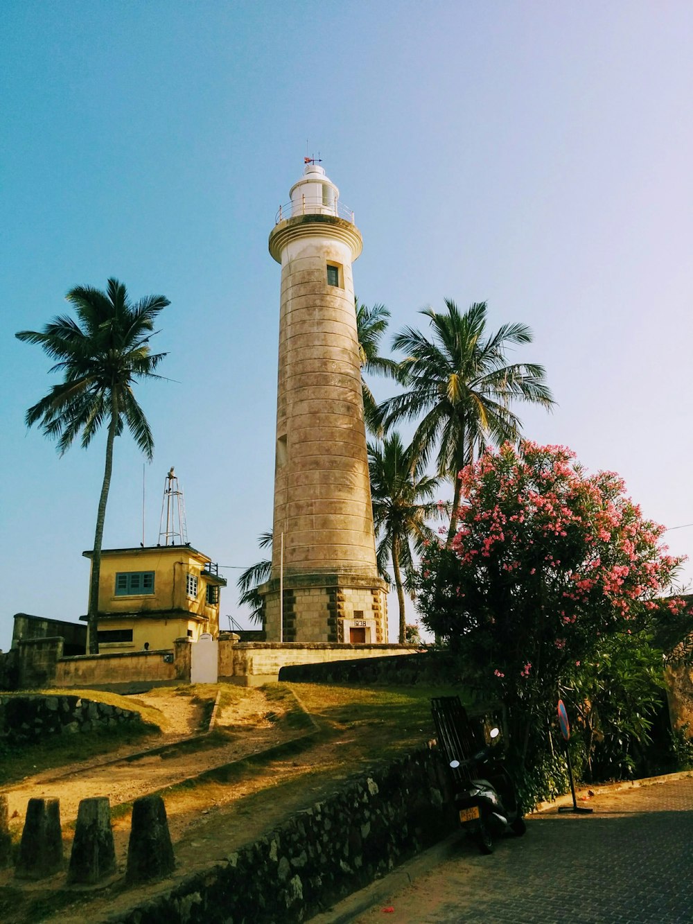 white and brown lighthouse near green trees during daytime
