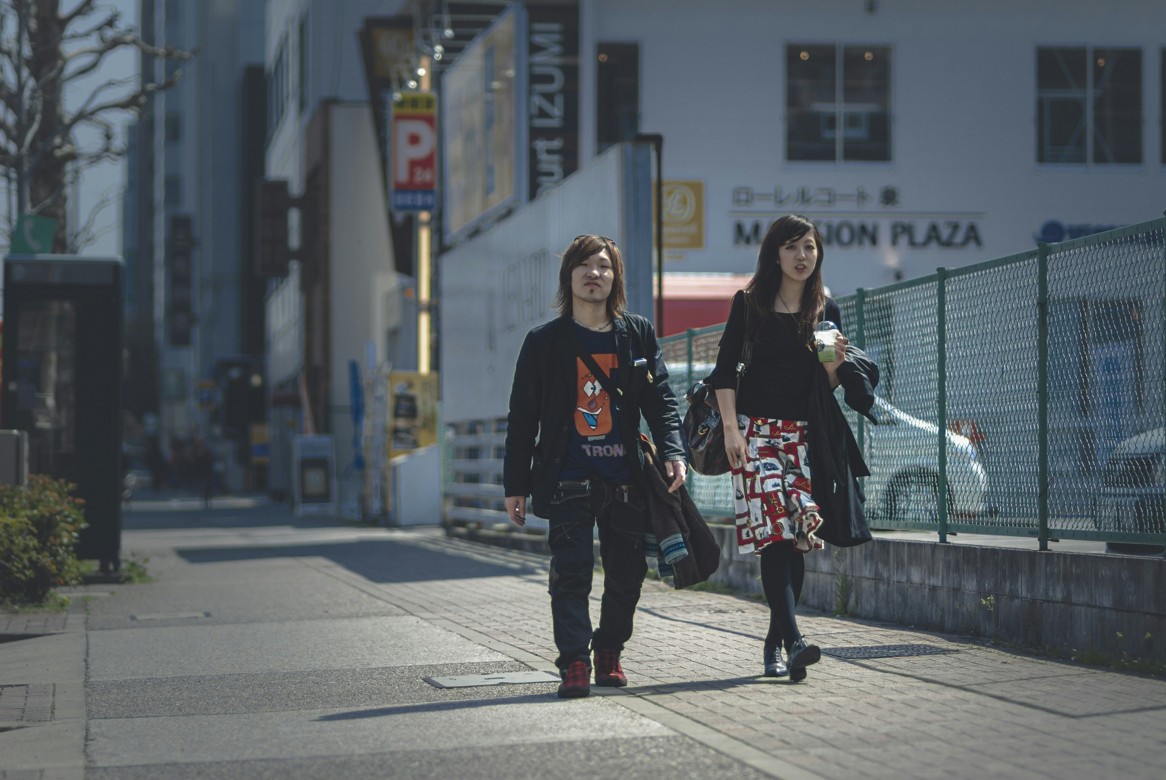 2 women standing on gray concrete floor during daytime