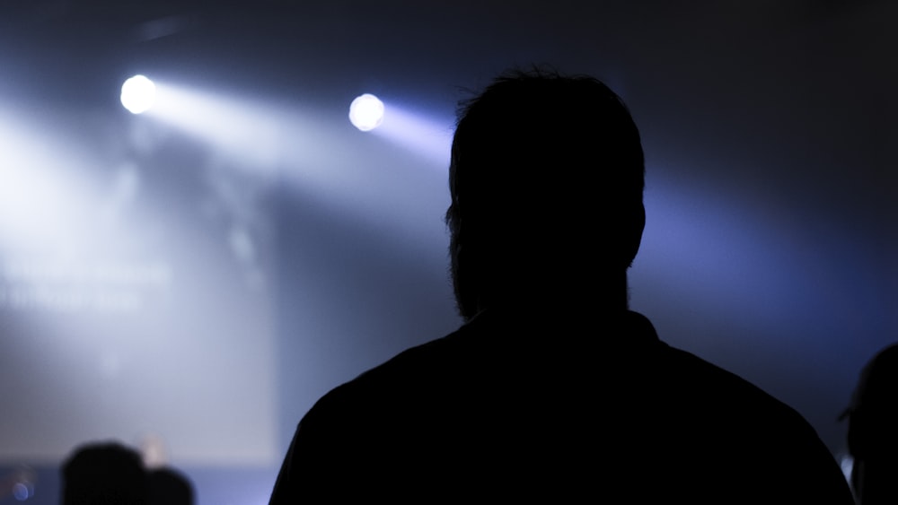 silhouette of man standing under blue sky during nighttime