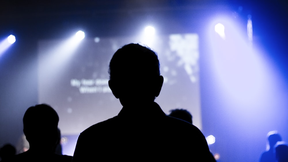 silhouette of man standing in front of stage