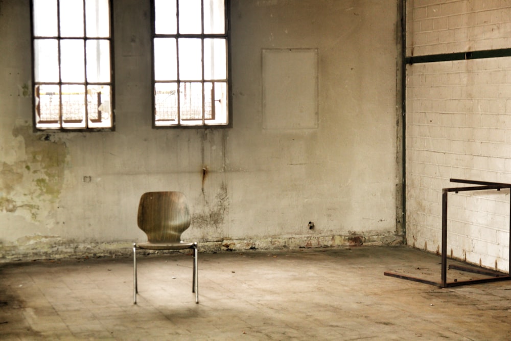 brown wooden seat beside white wall