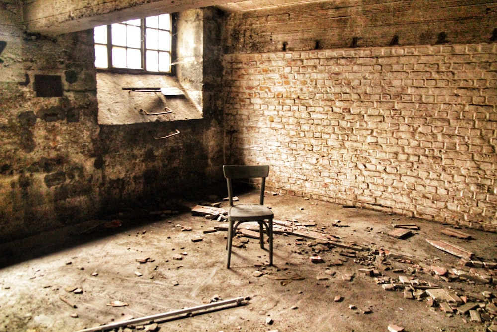 brown wooden chair beside brown brick wall