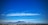 A panoramic view of Cape Town's coastline with Table Mountain in the background under a clear sky.