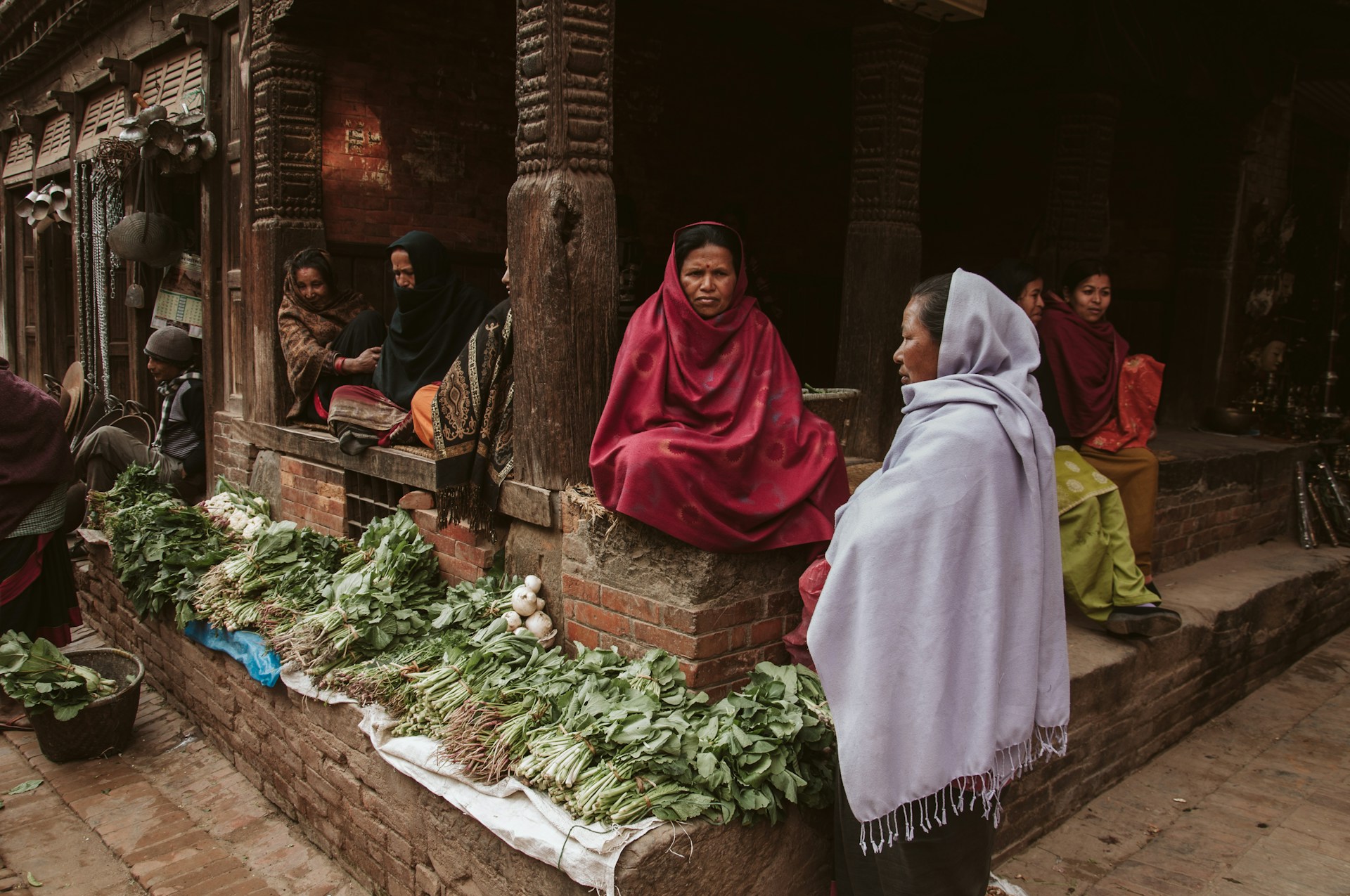 woman in red hijab sitting on brown wooden bench