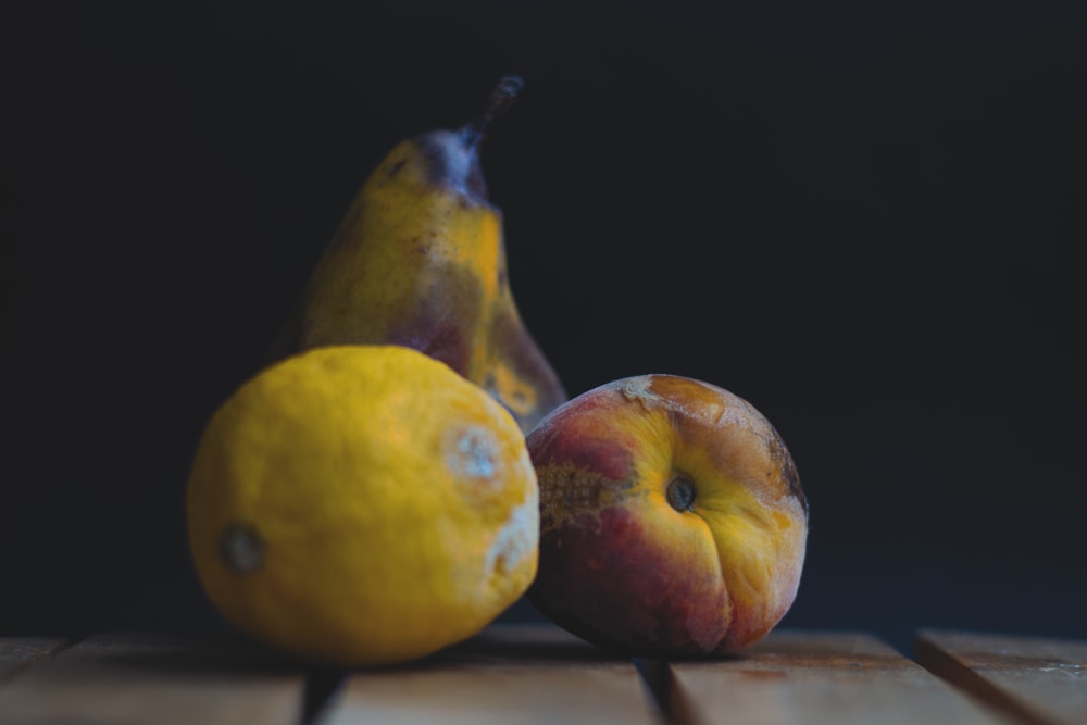 dos manzanas amarillas y rojas sobre una mesa de madera marrón