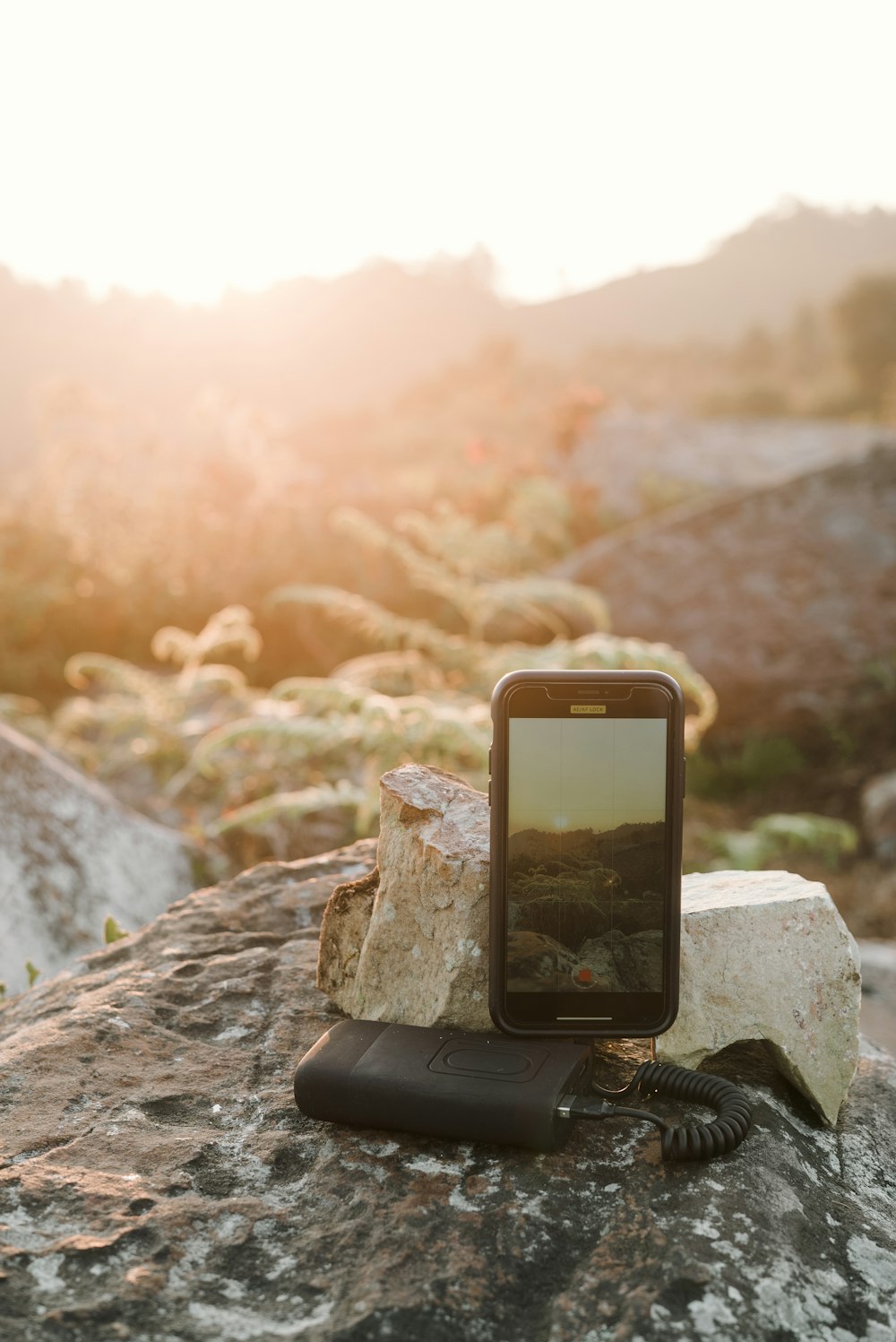 black iphone 4 on gray rock during daytime