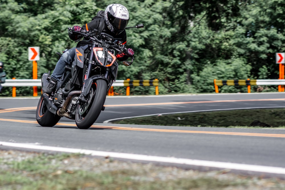 man in black helmet riding motorcycle on road during daytime