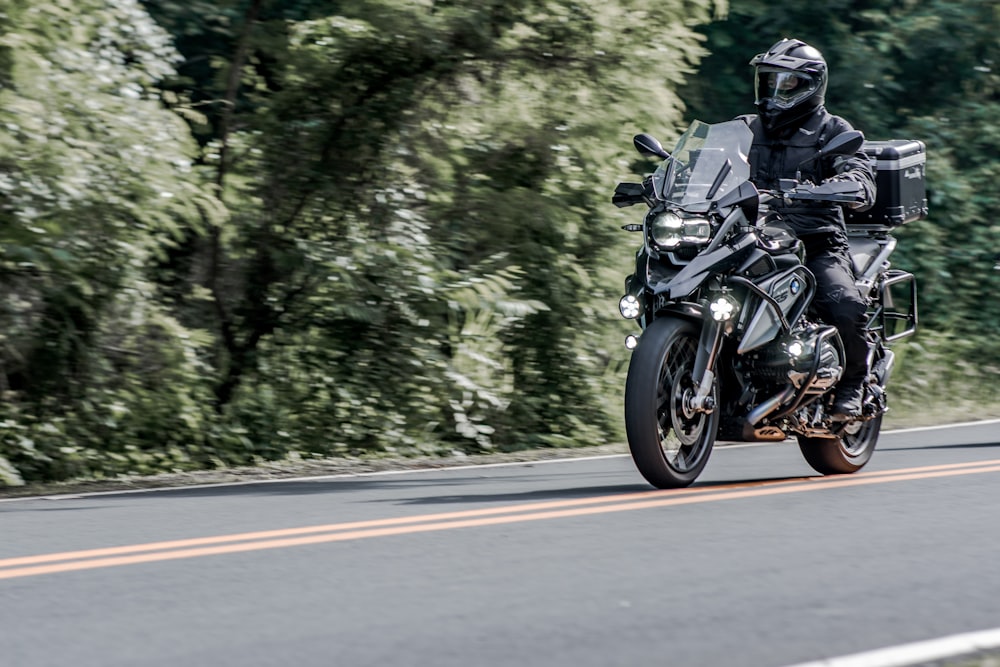 man riding motorcycle on road during daytime