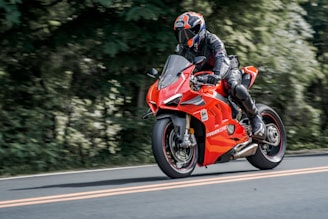 man in orange and black motorcycle suit riding on orange sports bike