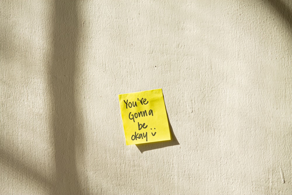 yellow sticky note on white textile