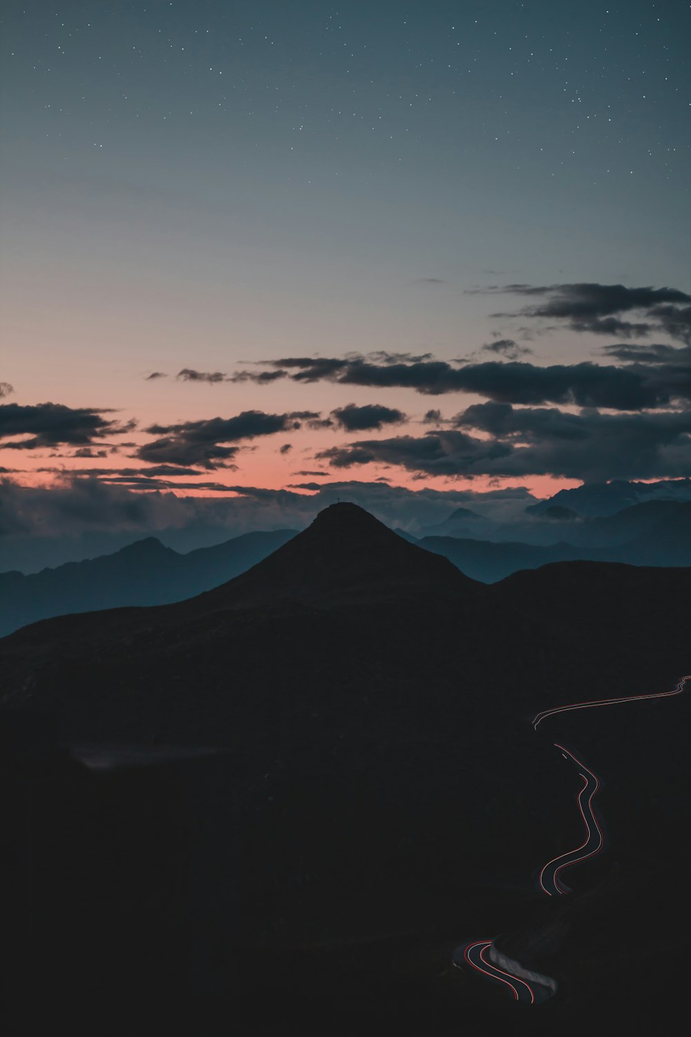 silhouette of mountain under cloudy sky during sunset