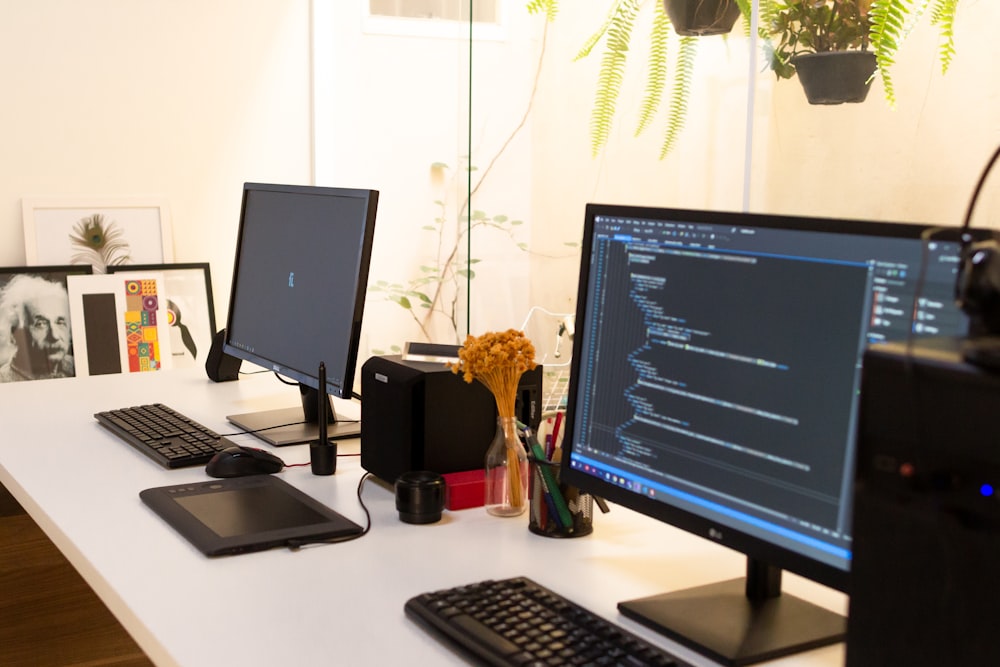 black flat screen computer monitor turned on beside black computer keyboard