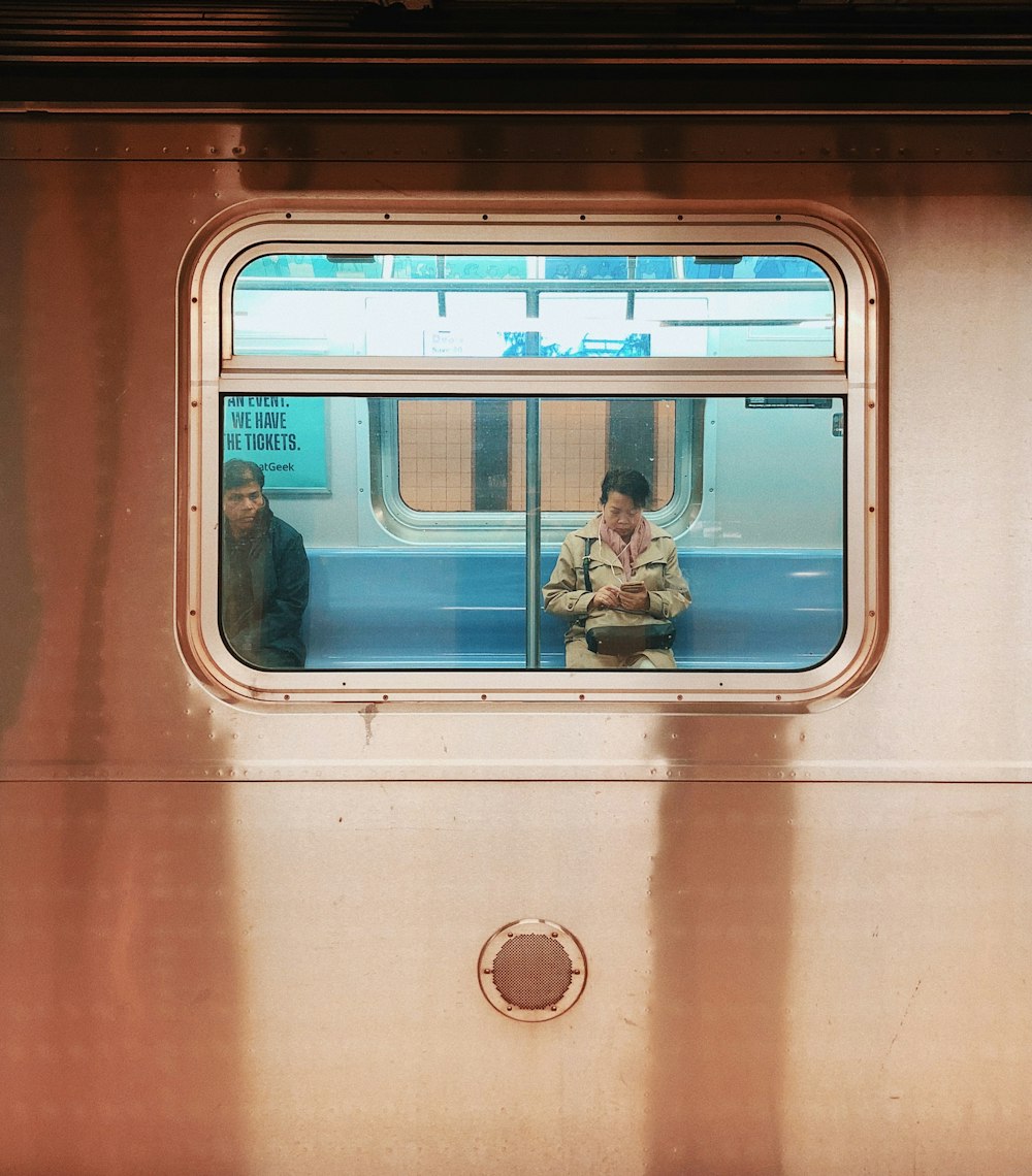 man in blue denim jeans sitting on train