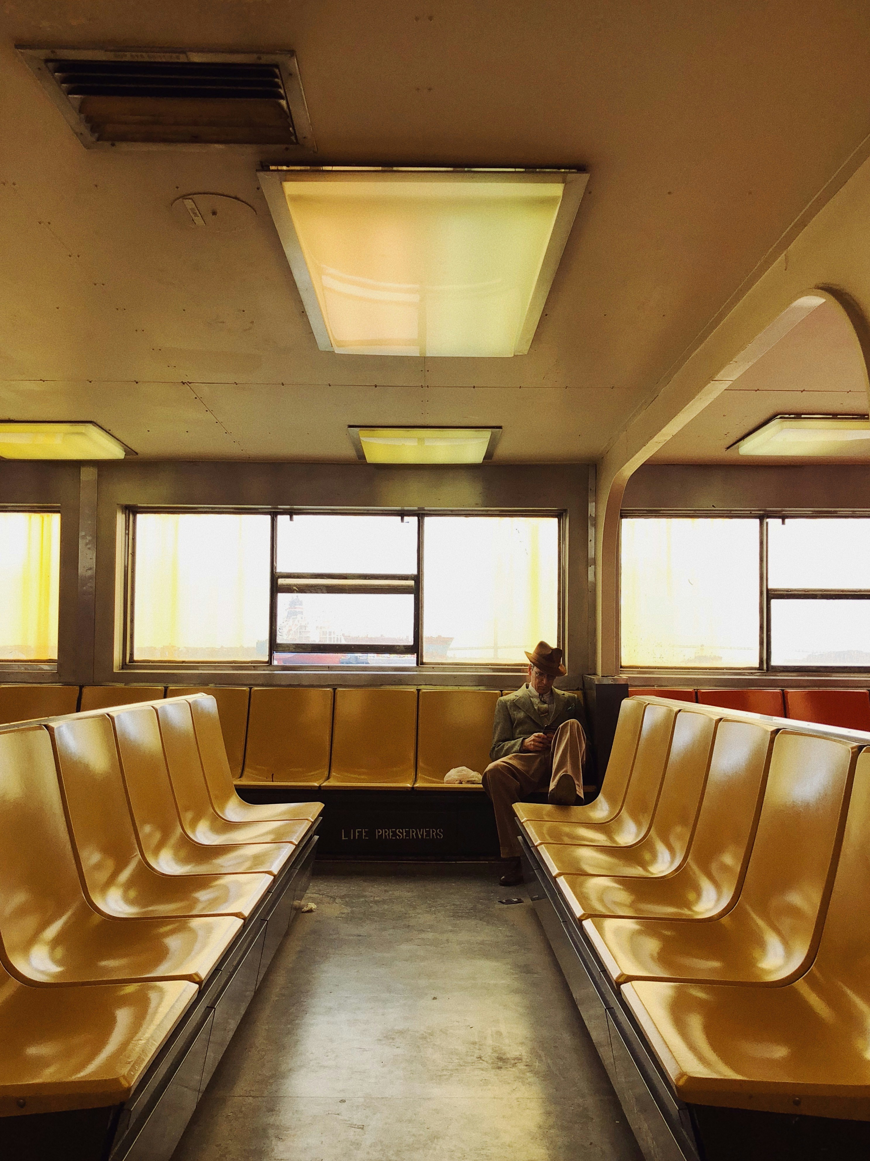 homem na jaqueta preta sentado na cadeira de couro branco