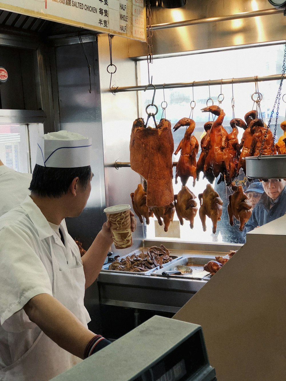 man in white t-shirt standing in front of raw meat