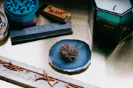 An array of colorful rolling papers and lighters neatly arranged on a rustic shelf.