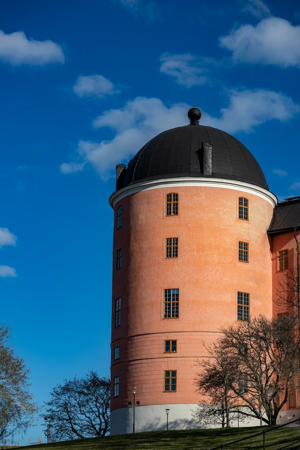 edificio in cemento marrone e nero sotto il cielo blu durante il giorno