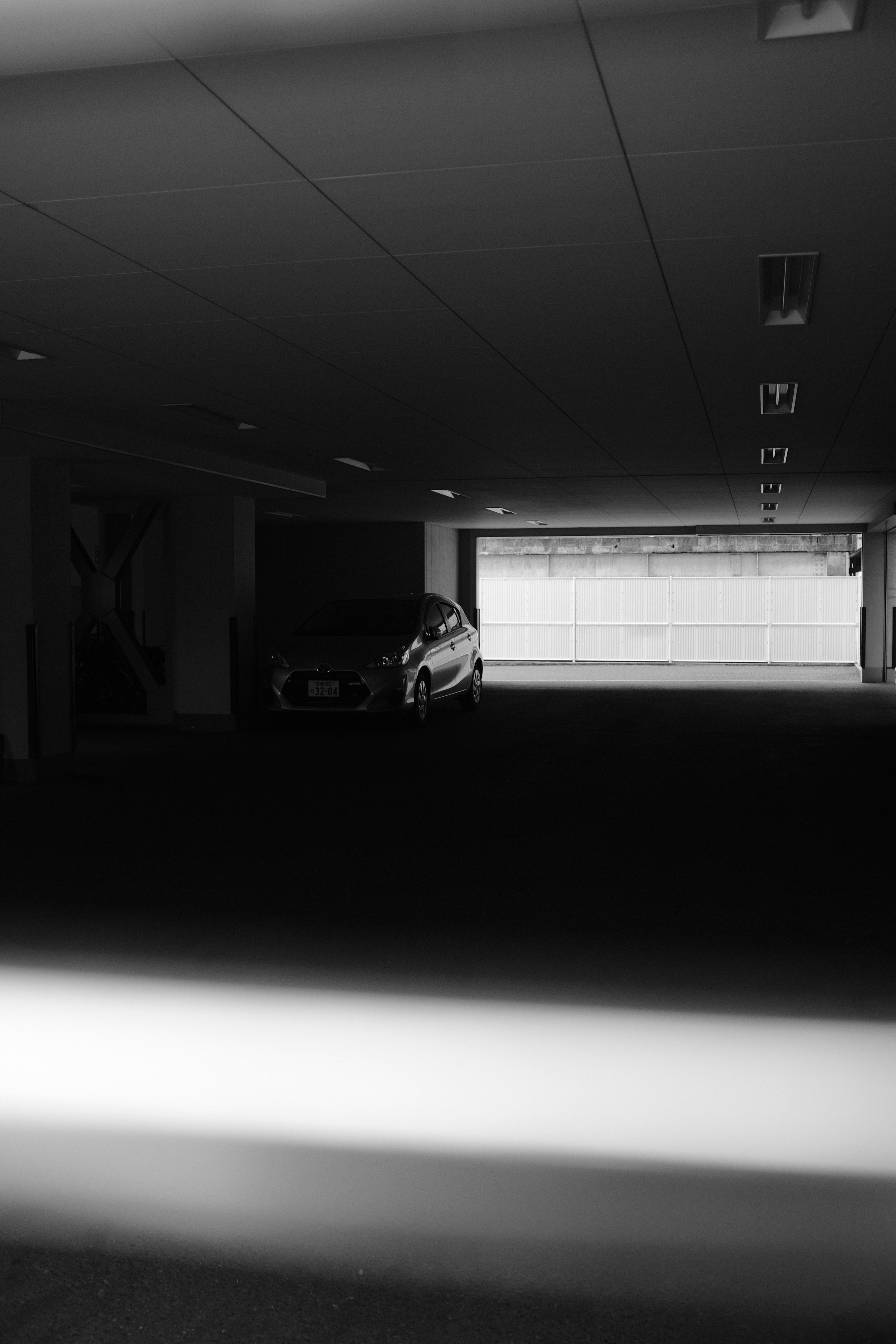grayscale photo of car in garage