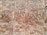 An arrangement of bricks forming a patterned design on a wall, featuring a mix of horizontal and diagonal placements creating geometric shapes. The bricks vary in shades of red and brown with some areas covered in mortar.