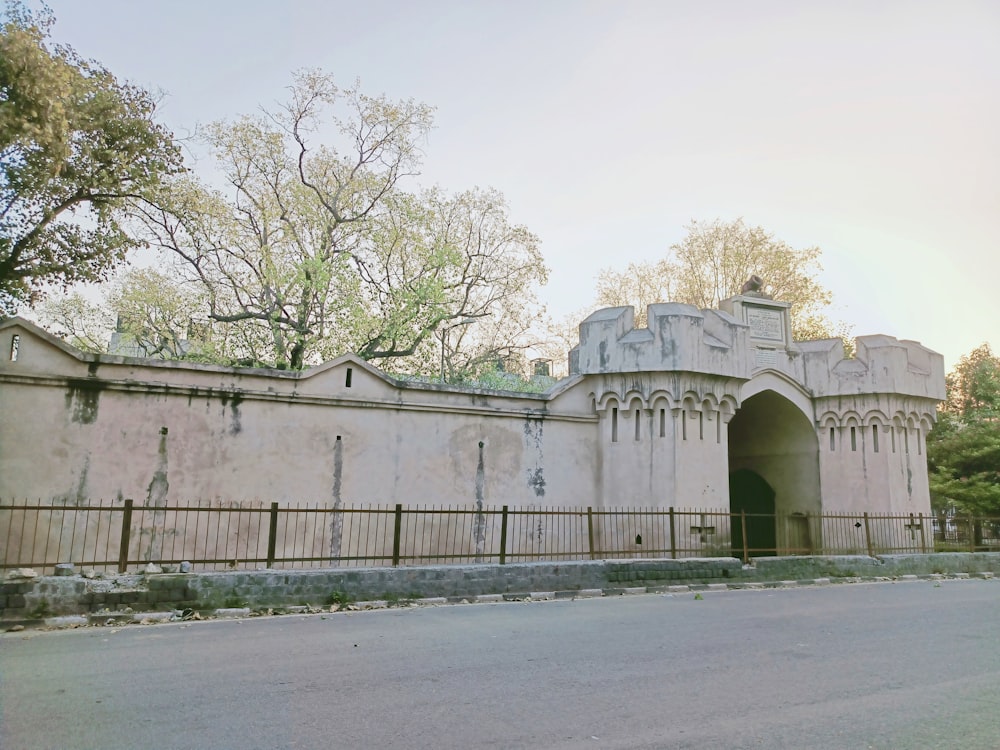 edificio in cemento bianco vicino agli alberi verdi durante il giorno