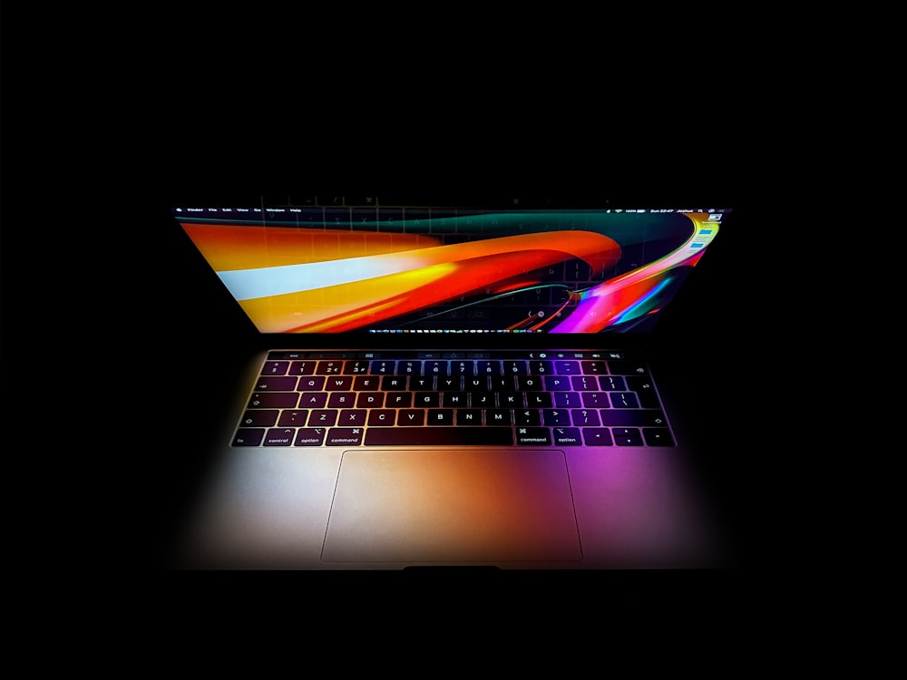 MacBook Pro activado y mostrando luces rojas, azules y amarillas