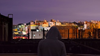 Evening city skyline with a person wearing lumina apparel, blending style with urban energy.